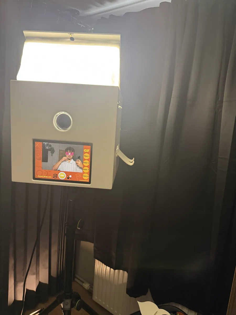 Fotobox mit Sofortdruck aufgebaut vor schwarzem Vorhang mit Studiolicht