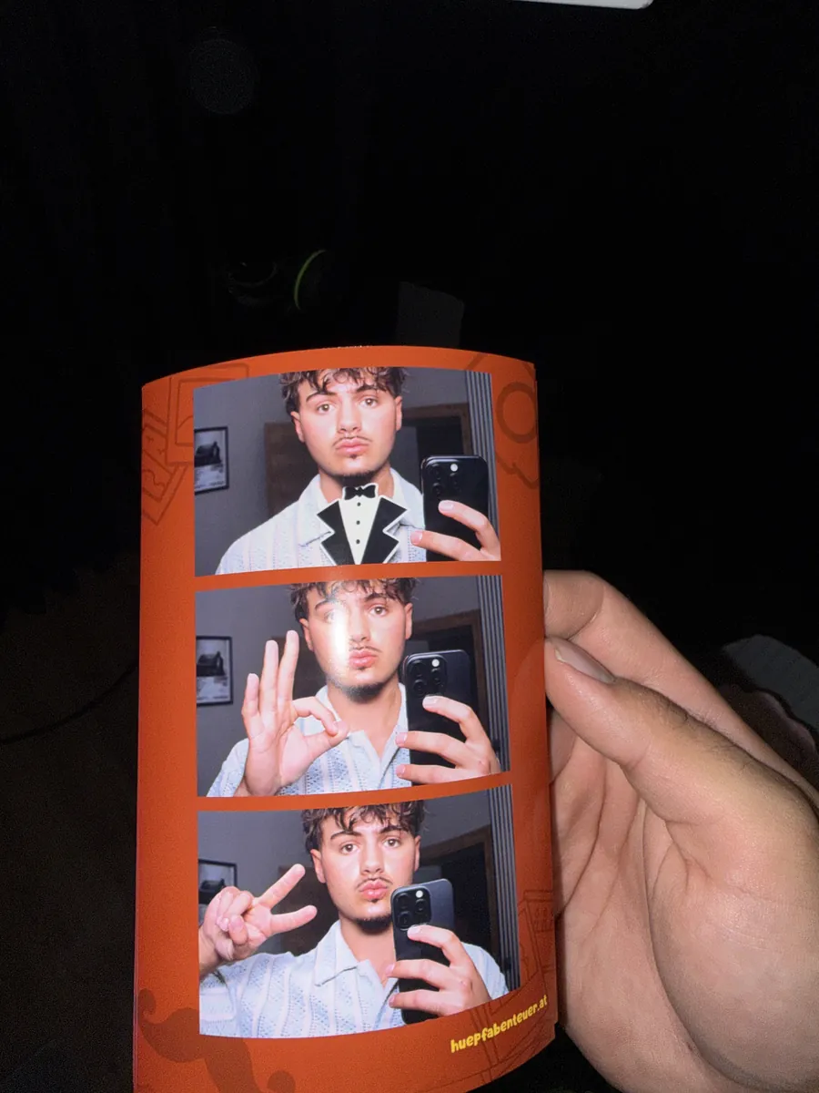 Fotostreifen mit drei Aufnahmen aus der Fotobox in der Hand